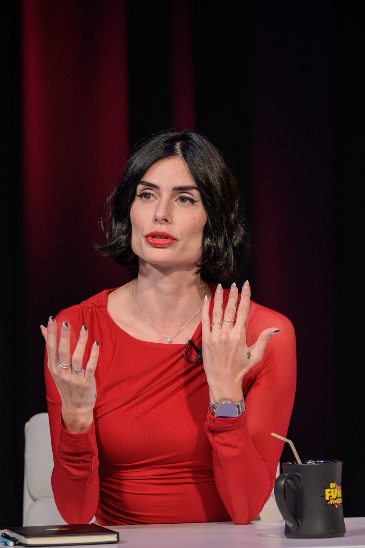Carina Cunha in red, speaking as a guest on Go Fund Yourself!