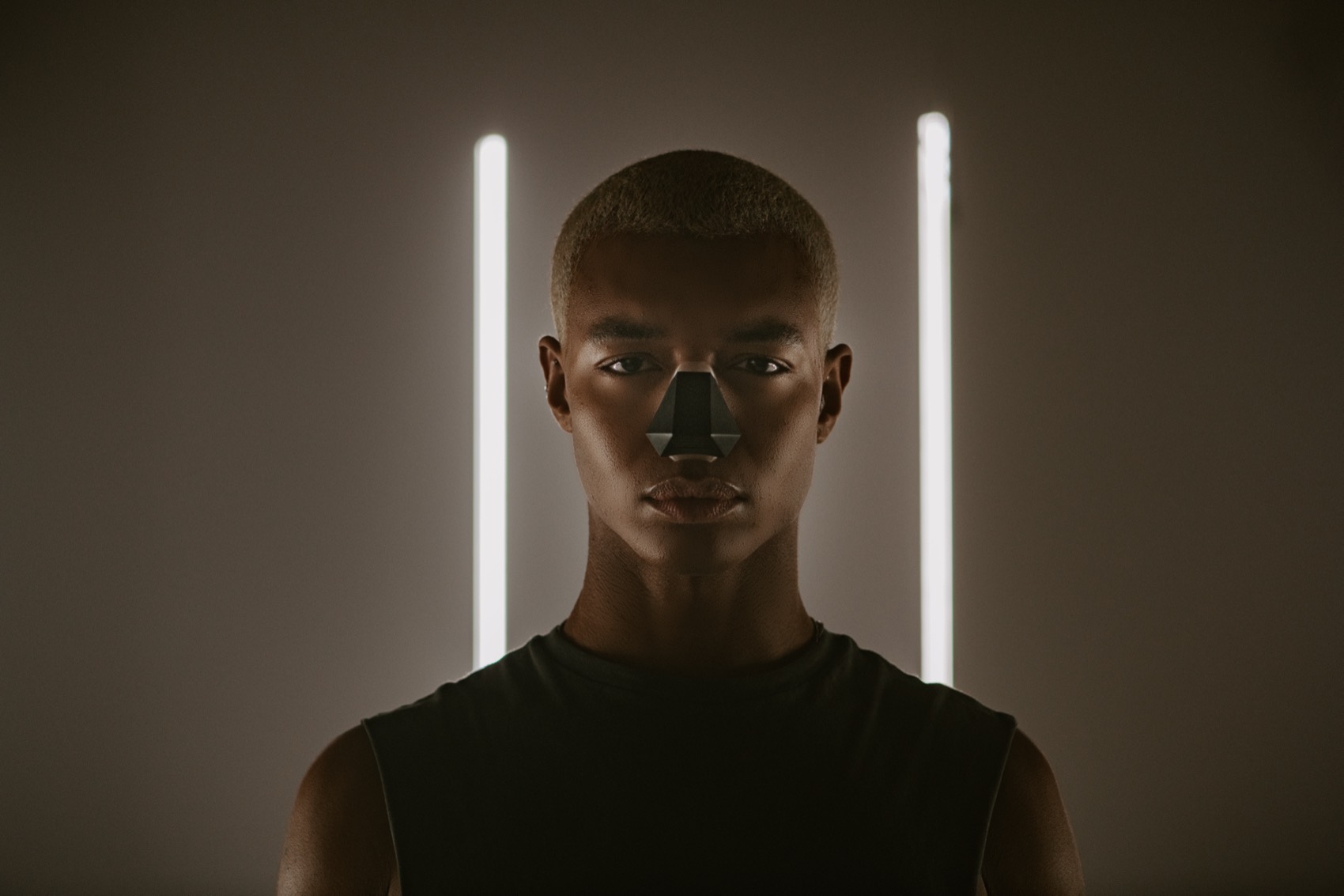 A model between two vertical light bars, wearing the black Nosy