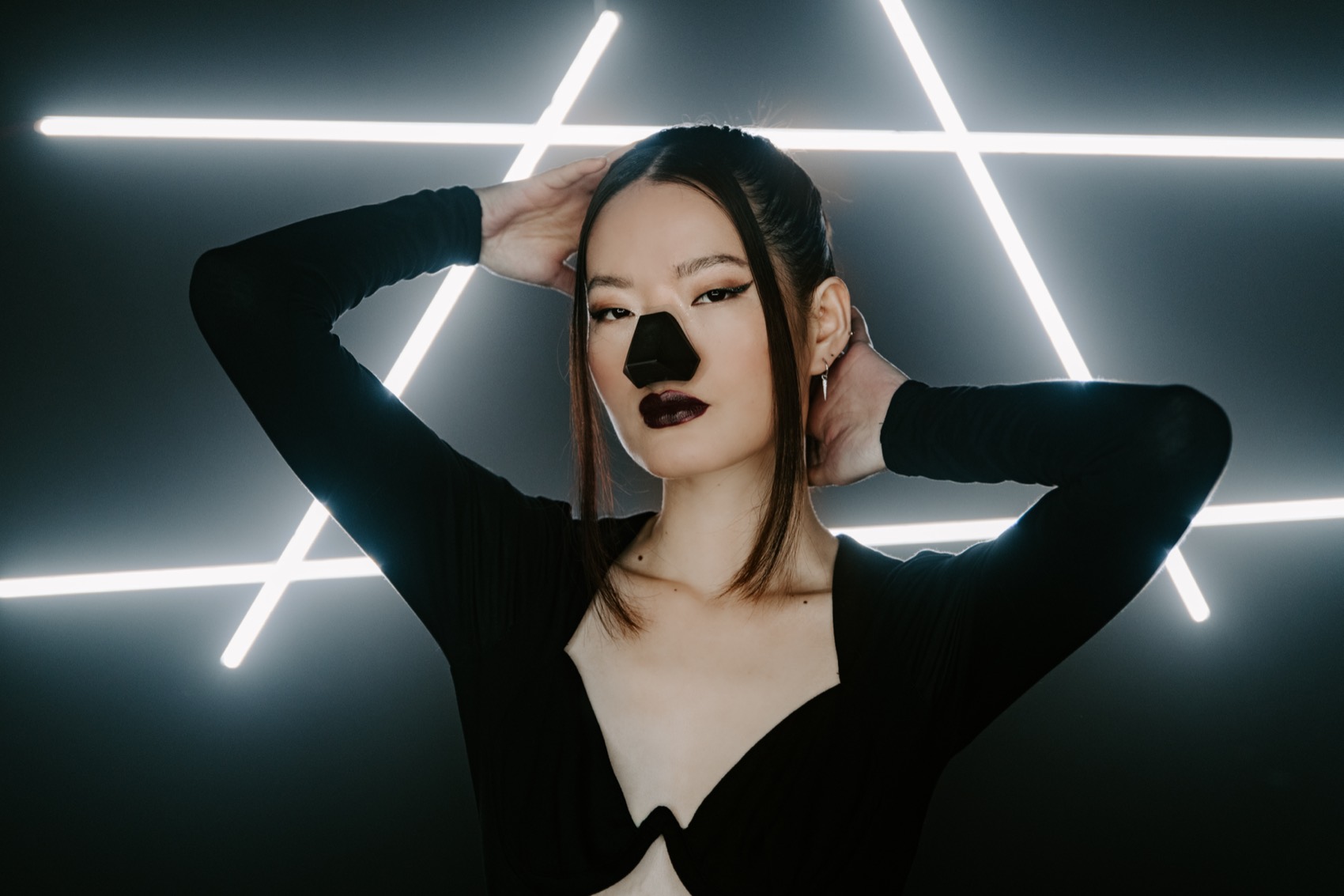 A model with her hand in her hair wearing Nosy inside the neon star